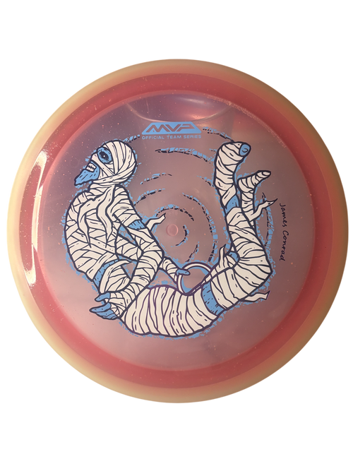 MVP Trail Proton Particle James Conrad Halloween Team Series 2026 – distance driver med mumiedesign, skimrande partiklar och självlysande kant.